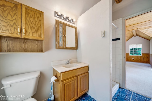 4900 E Hudlow Rd, Hayden, ID 83835 - bathroom with vanity, tiled shower, lofted ceiling, and wooden walls