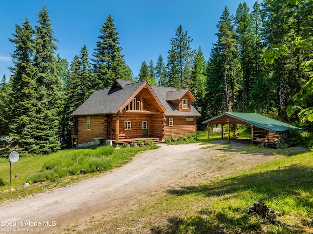 4900 E Hudlow Rd, Hayden, ID 83835 - log-style house featuring driveway, log siding, a carport, and a front yard