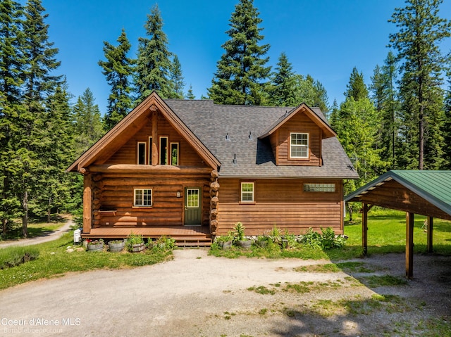 4900 E Hudlow Rd, Hayden, ID 83835 - cabin featuring a porch, a shingled roof, log exterior, and a carport