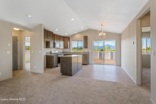 10519 Liverpool Loop, Hayden, ID 83835 - kitchen featuring appliances with stainless steel finishes, light colored carpet, lofted ceiling, a center island, and healthy amount of natural light