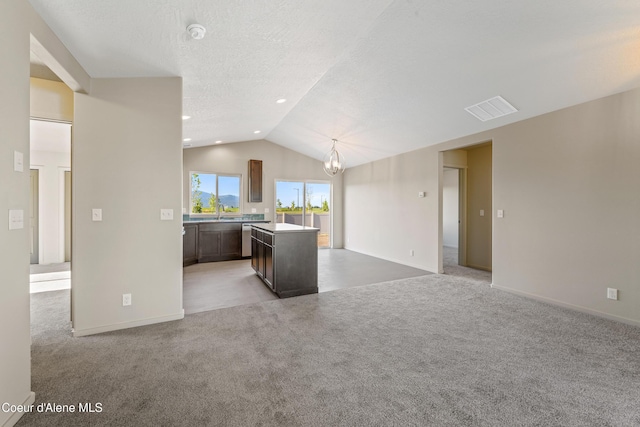 10519 Liverpool Loop, Hayden, ID 83835 - unfurnished living room featuring vaulted ceiling, a chandelier, carpet floors, and a textured ceiling