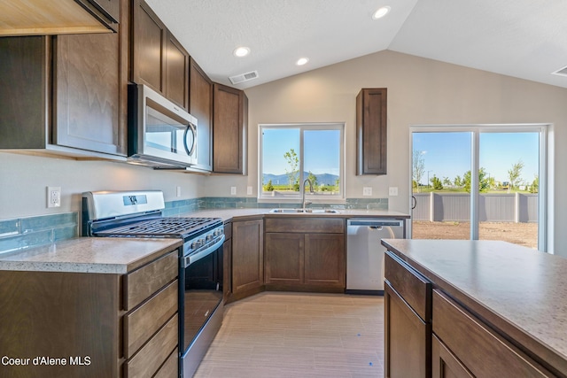 10519 Liverpool Loop, Hayden, ID 83835 - kitchen featuring stainless steel appliances, lofted ceiling, recessed lighting, dark brown cabinets, and light countertops