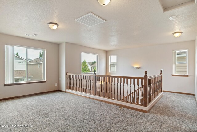 7833 N Hilliard Ct, Coeur Dalene, ID 83815 - carpeted spare room with a smoke detector, plenty of natural light, and a textured ceiling