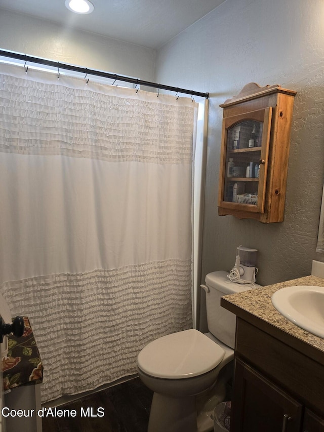 7812 W Kayak Ct, Rathdrum, ID 83858 - full bath with vanity, wood finished floors, a textured wall, and curtained shower