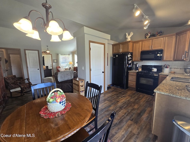 7812 W Kayak Ct, Rathdrum, ID 83858 - dining room featuring dark wood-style floors, track lighting, vaulted ceiling, and a chandelier