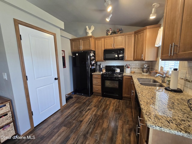 7812 W Kayak Ct, Rathdrum, ID 83858 - kitchen featuring black appliances, vaulted ceiling, dark wood-style flooring, backsplash, and light stone countertops