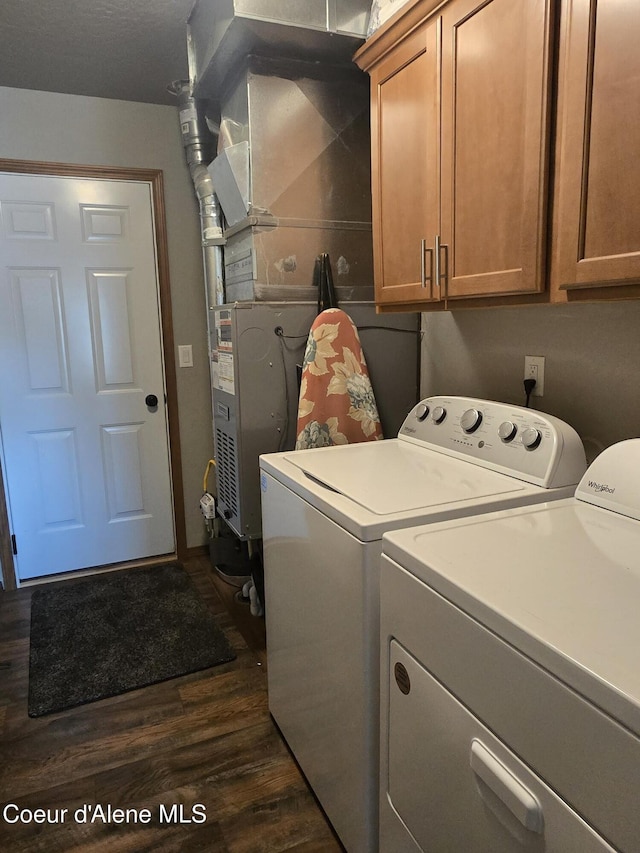 7812 W Kayak Ct, Rathdrum, ID 83858 - washroom with washing machine and dryer, cabinet space, and dark wood-type flooring