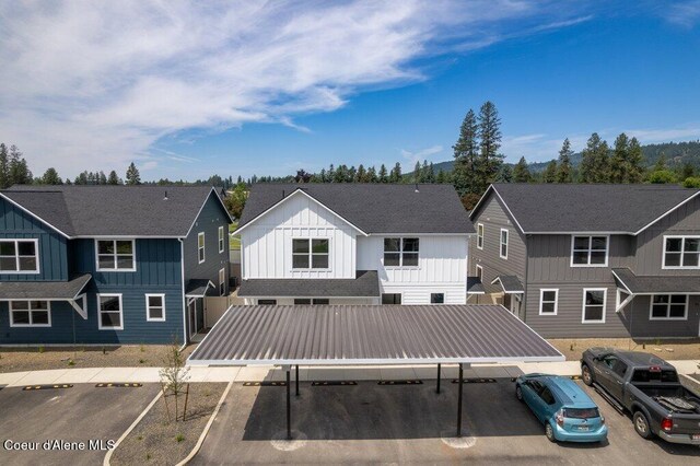 8 Potlatch Loop, Priest River, ID 83856 - back of house with covered and uncovered parking, board and batten siding, and a residential view