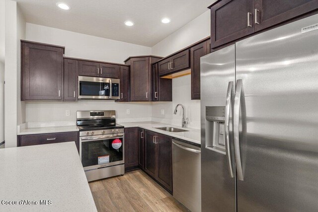 8 Potlatch Loop, Priest River, ID 83856 - kitchen with stainless steel appliances, light countertops, light wood finished floors, dark brown cabinetry, and recessed lighting