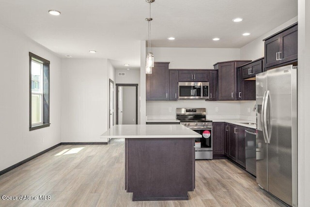 8 Potlatch Loop, Priest River, ID 83856 - kitchen with appliances with stainless steel finishes, dark brown cabinets, light countertops, light wood-style flooring, and a kitchen island