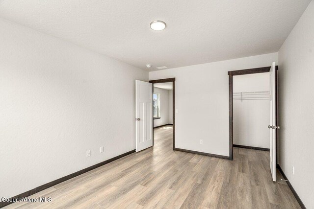 8 Potlatch Loop, Priest River, ID 83856 - unfurnished bedroom with wood finished floors, a spacious closet, and a closet