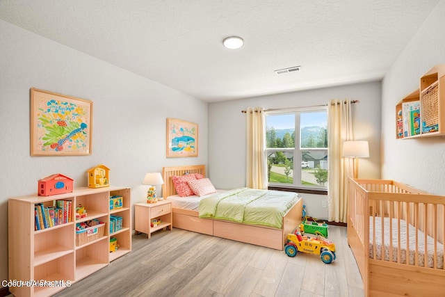 8 Potlatch Loop, Priest River, ID 83856 - bedroom with wood finished floors and a textured ceiling