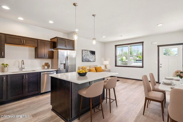 8 Potlatch Loop, Priest River, ID 83856 - kitchen featuring appliances with stainless steel finishes, light countertops, light wood-style flooring, a kitchen island, and dark brown cabinets
