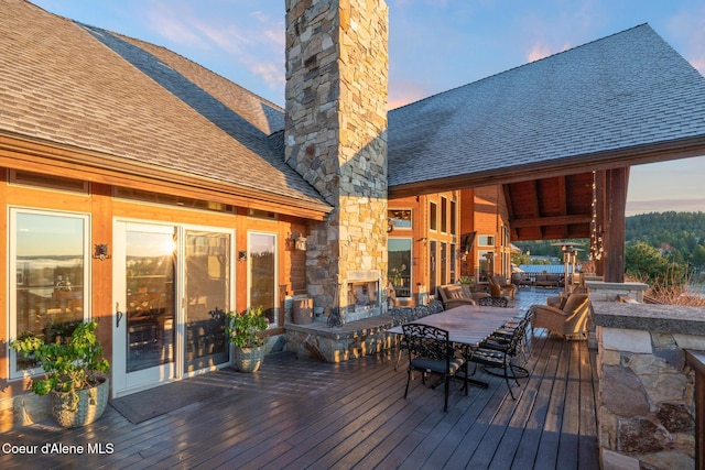 5841 W Clemetson Rd, Coeur Dalene, ID 83814 - wooden terrace with an outdoor stone fireplace and outdoor dining space