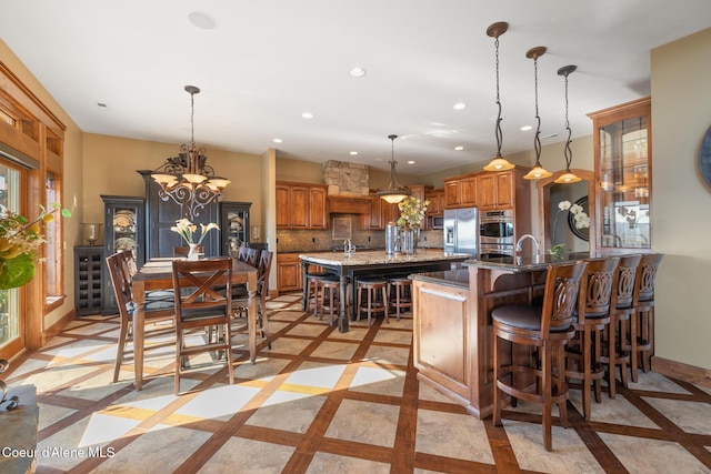 5841 W Clemetson Rd, Coeur Dalene, ID 83814 - kitchen with inlaid floor details, brown cabinets, a kitchen breakfast bar, recessed lighting, and stainless steel appliances