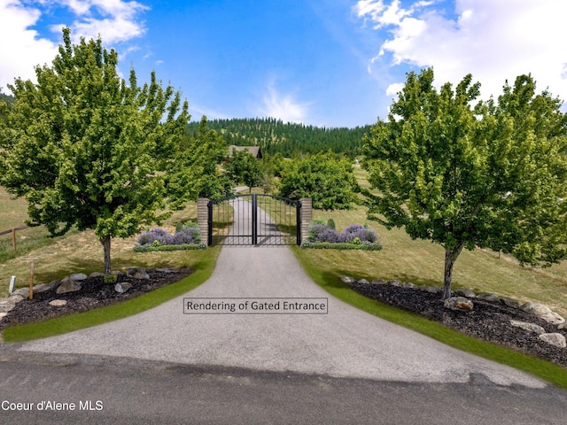 5841 W Clemetson Rd, Coeur Dalene, ID 83814 - view of asphalt driveway with a gate and a forest view