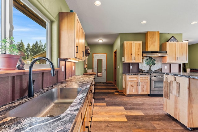 64 Heights Loop, Bonners Ferry, ID 83805 - kitchen with light brown cabinets, wall chimney range hood, stainless steel stove, dark wood-style flooring, and dark countertops