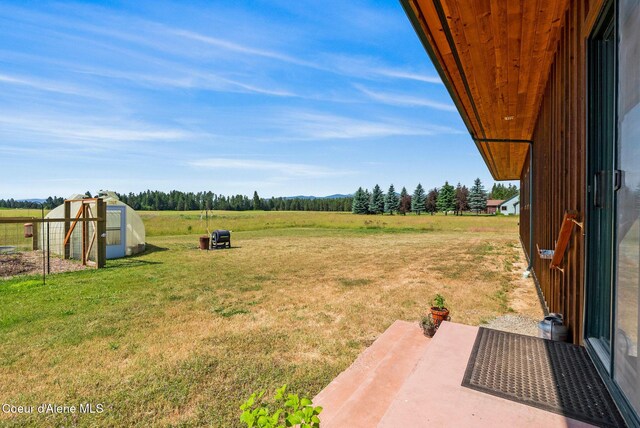 64 Heights Loop, Bonners Ferry, ID 83805 - view of grassy yard featuring a rural view, a patio, and an outbuilding