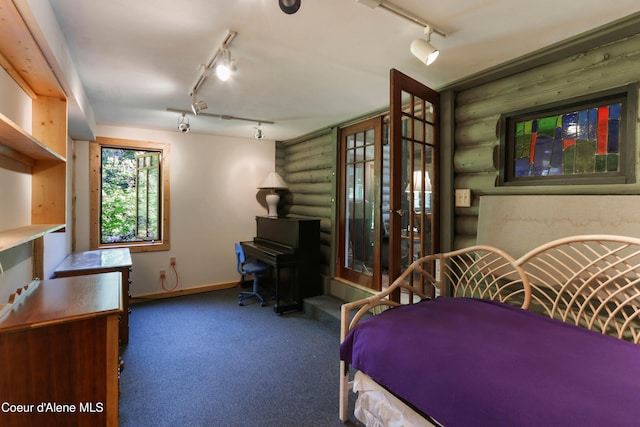 1283 N Wrenco Rd, Sandpoint, ID 83864 - bedroom with track lighting, log walls, a wood stove, and carpet