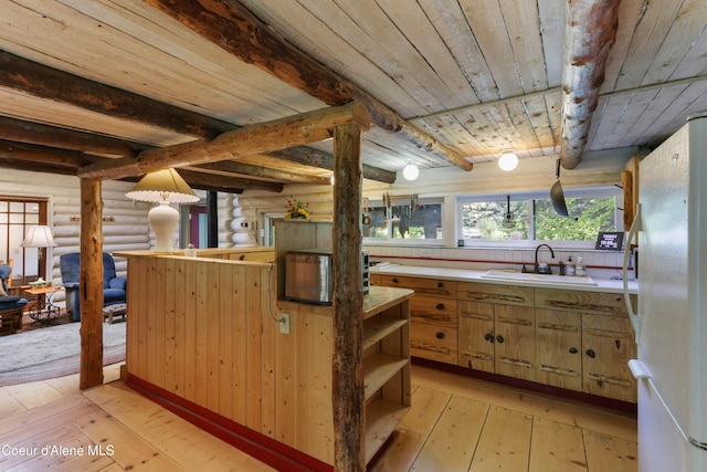 1283 N Wrenco Rd, Sandpoint, ID 83864 - kitchen featuring freestanding refrigerator, rustic walls, open shelves, light wood-style flooring, and a wood ceiling with exposed beams