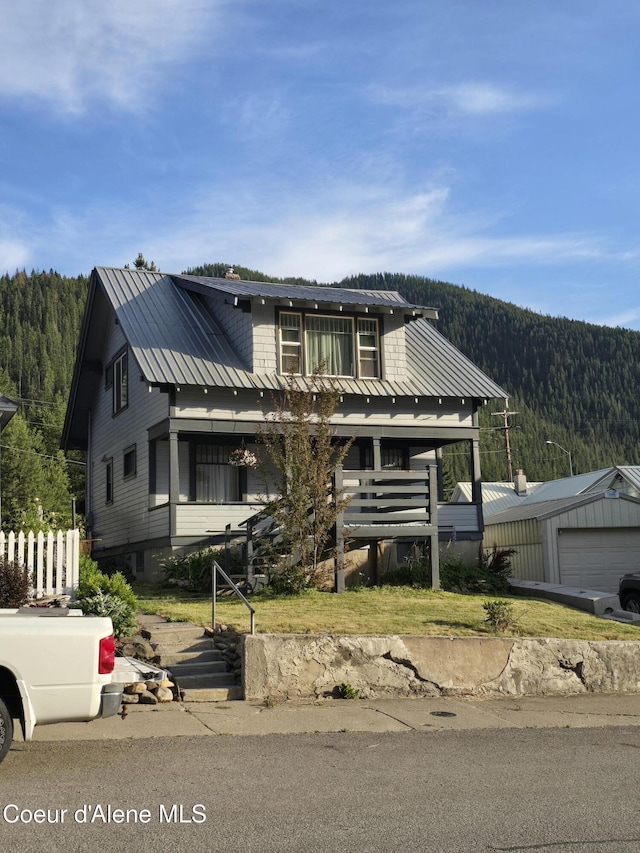 312 Park St, Mullan, ID 83846 - view of front of house featuring a forest view, a metal roof, and a mountain view