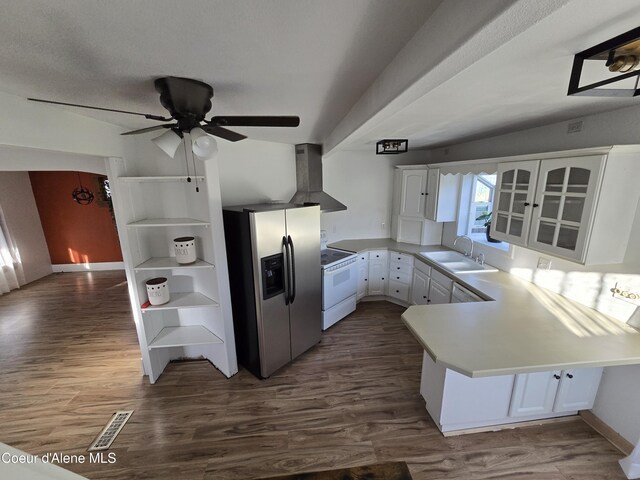 312 Park St, Mullan, ID 83846 - kitchen with stainless steel fridge, white range with electric stovetop, wall chimney exhaust hood, a peninsula, and white cabinets