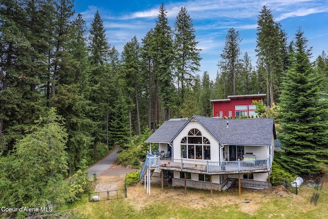 7605 W Sanders Rd, Coeur Dalene, ID 83814 - back of property with stairway, a shingled roof, a forest view, and a deck