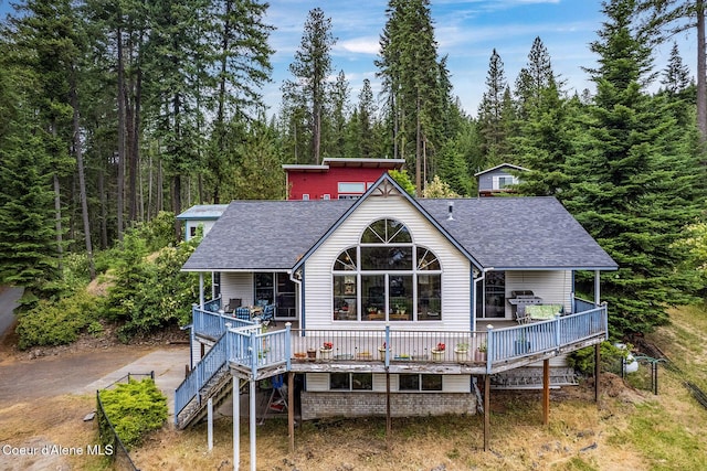 7605 W Sanders Rd, Coeur Dalene, ID 83814 - rear view of house featuring roof with shingles, a wooded view, and a porch