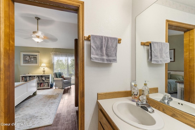 7605 W Sanders Rd, Coeur Dalene, ID 83814 - bathroom with vanity, a ceiling fan, wood finished floors, and connected bathroom
