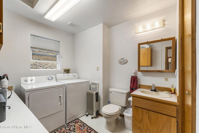 7605 W Sanders Rd, Coeur Dalene, ID 83814 - bathroom featuring independent washer and dryer, radiator, and vanity