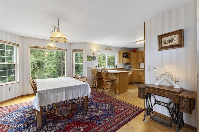 7605 W Sanders Rd, Coeur Dalene, ID 83814 - dining area with wallpapered walls and light wood-type flooring
