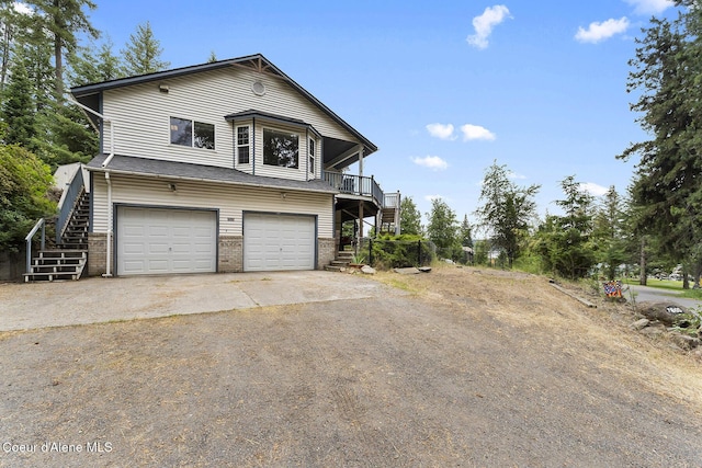7605 W Sanders Rd, Coeur Dalene, ID 83814 - view of front facade with stairway, driveway, brick siding, and a garage