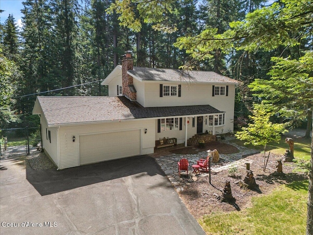 12321 N Sherwood Ct, Hayden, ID 83835 - traditional-style home with driveway, a chimney, and an attached garage