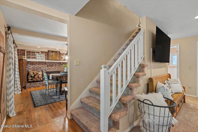 12321 N Sherwood Ct, Hayden, ID 83835 - staircase featuring a brick fireplace and wood finished floors