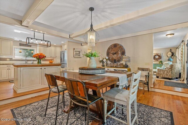 12321 N Sherwood Ct, Hayden, ID 83835 - dining space with beam ceiling, light wood-type flooring, and a chandelier