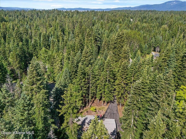 12321 N Sherwood Ct, Hayden, ID 83835 - aerial overview of property's location featuring a heavily wooded area and a mountainous background