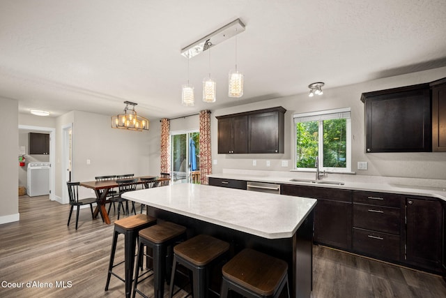 120 E Walnut Ave, Coeur Dalene, ID 83814 - kitchen featuring washer / clothes dryer, light countertops, a kitchen breakfast bar, and dark wood finished floors