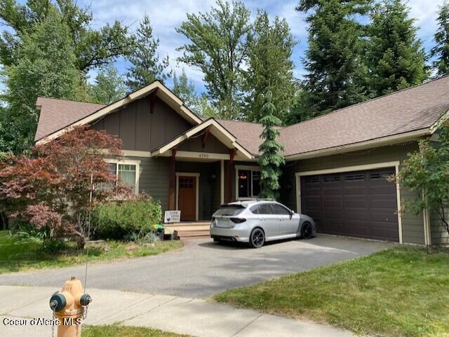 4310 Burns Ct, Sandpoint, ID 83864 - view of front of home with asphalt driveway, a garage, board and batten siding, and roof with shingles