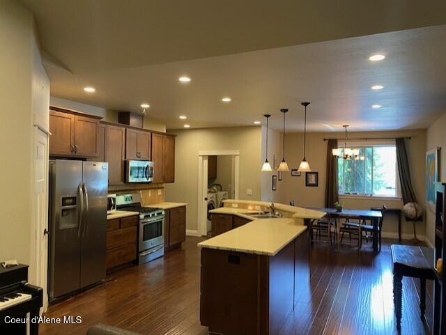 4310 Burns Ct, Sandpoint, ID 83864 - kitchen with appliances with stainless steel finishes, dark wood finished floors, recessed lighting, light countertops, and a chandelier