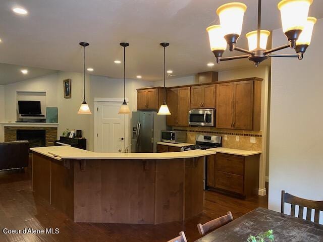 4310 Burns Ct, Sandpoint, ID 83864 - kitchen with stainless steel appliances, dark wood-type flooring, brown cabinets, decorative backsplash, and a chandelier