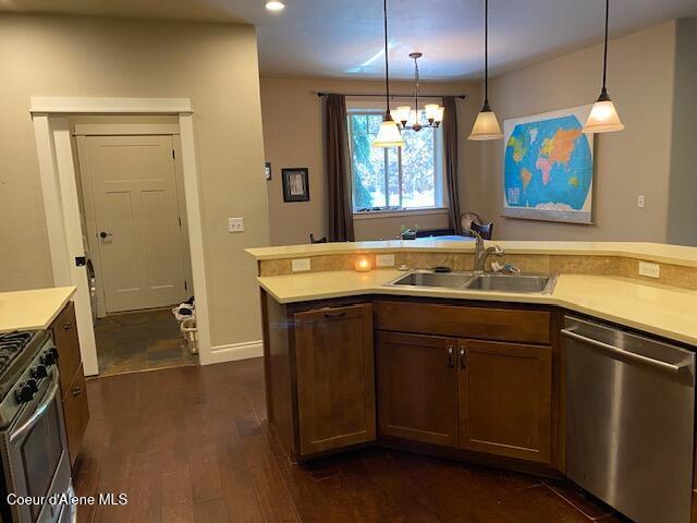 4310 Burns Ct, Sandpoint, ID 83864 - kitchen with appliances with stainless steel finishes, light countertops, dark wood-type flooring, a chandelier, and hanging light fixtures