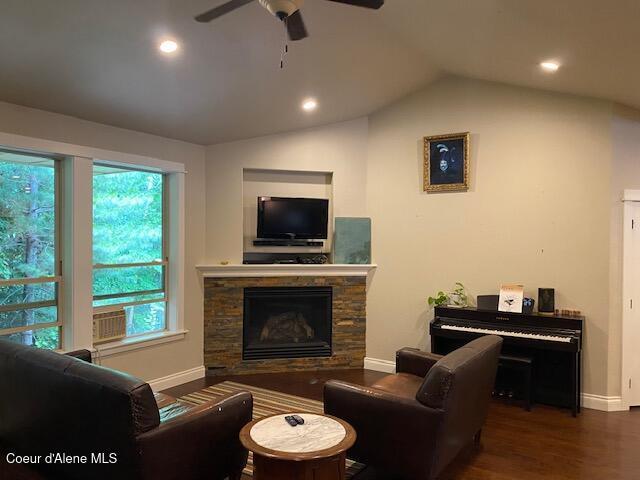 4310 Burns Ct, Sandpoint, ID 83864 - living area featuring wood finished floors, a ceiling fan, a stone fireplace, vaulted ceiling, and recessed lighting