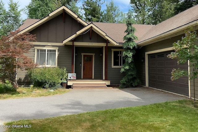 4310 Burns Ct, Sandpoint, ID 83864 - view of front facade featuring board and batten siding, asphalt driveway, an attached garage, and roof with shingles