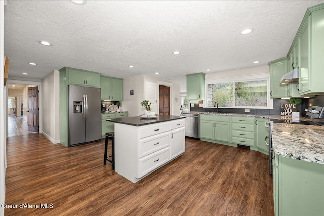 3772 S Schilling Loop, Post Falls, ID 83854 - kitchen featuring appliances with stainless steel finishes, green cabinetry, under cabinet range hood, recessed lighting, and a textured ceiling