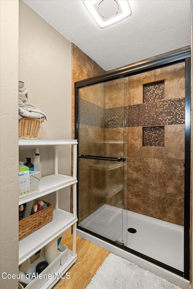 3772 S Schilling Loop, Post Falls, ID 83854 - full bathroom featuring a stall shower and wood finished floors
