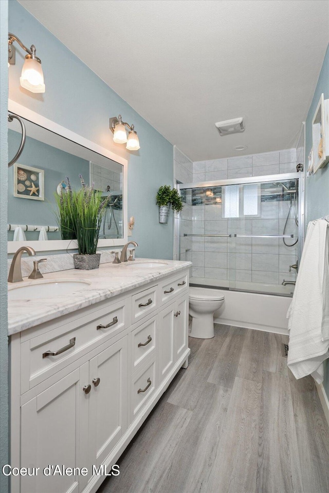 3772 S Schilling Loop, Post Falls, ID 83854 - full bathroom with combined bath / shower with glass door, double vanity, and wood finished floors
