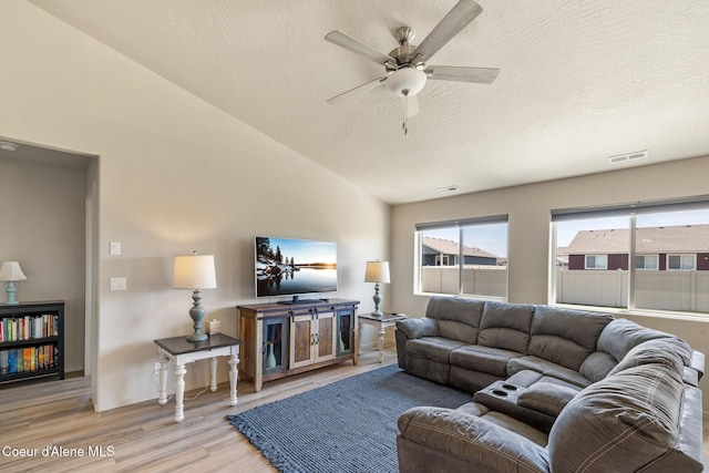 10413 N Belgrave Loop, Hayden, ID 83835 - living room with light wood-style floors, ceiling fan, a textured ceiling, and lofted ceiling