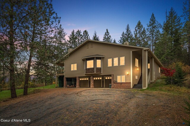 7611 W Clemetson Rd, Coeur Dalene, ID 83814 - view of front facade with a chimney, driveway, an attached garage, and brick siding