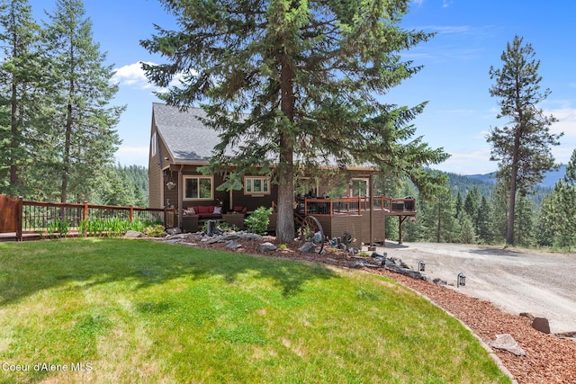 1529 S Saddleback Dr, Coeur Dalene, ID 83814 - rear view of house with a deck, a lawn, a shingled roof, and a view of trees