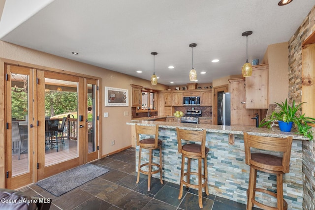 1529 S Saddleback Dr, Coeur Dalene, ID 83814 - kitchen featuring appliances with stainless steel finishes, a peninsula, recessed lighting, decorative backsplash, and light stone countertops